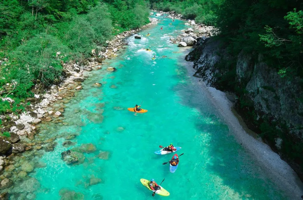 Group kayaking down the Soča stream